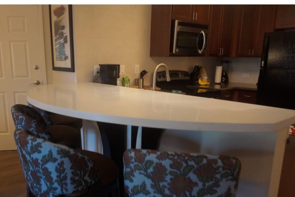White counter with high chairs at the kitchen area.